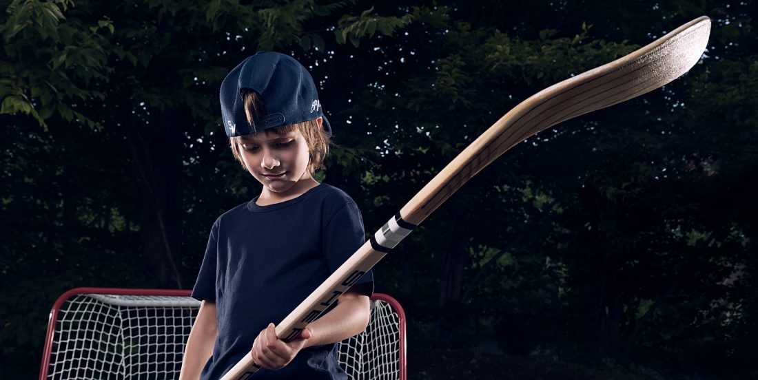 jeune garçon avec bâton de hockey Sher-Wood dans les mains